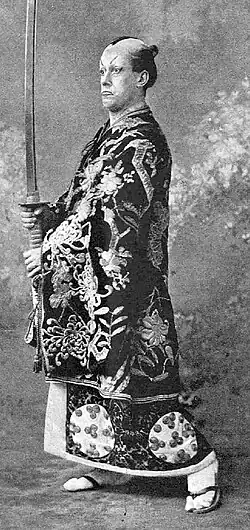 Man in Japanese costume, carrying a large sword