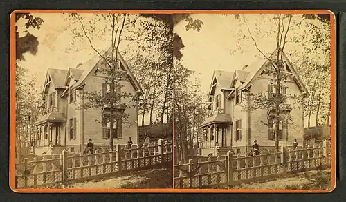 People in front of a large wood-frame house, 19th-20th century