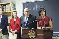 Angela Alsobrooks behind a podium and next to Larry Hogan