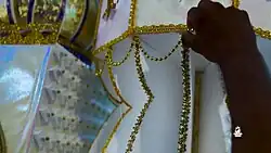 Man putting beads on a Tadjah