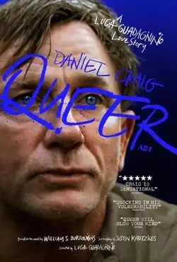 A middle-aged man stares out, in front of a plain blue background.