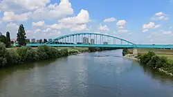 River under bridge with city in background
