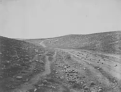 A view of the "Valley of the Shadow of Death" near Sevastopol, taken by Roger Fenton in March 1855. It was so named by soldiers because of the number of cannonballs that landed there, falling short of their target, during the siege.[35]