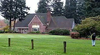 Photograph of the Rose City Golf Clubhouse, with a golfer in the foreground