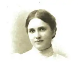 B&W portrait photo of a young woman wearing a pale blouse, with her hair in an up-do