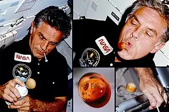 Karl Henize, STS-51F mission specialist, creates frothy, fizzing Pepsi soda balls during the Carbonated Beverage Dispenser Evaluation