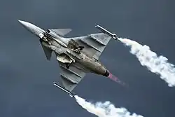 Jet aircraft performing rolls while climbing