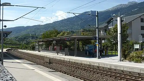 Double-tracked railway line with canopy-covered concrete platforms