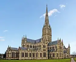 Salisbury Cathedral from the East showing features of the North Facade and grey masonry spire. The exterior shows the same harmony in the groupings of simple windows that is apparent in the interior view.