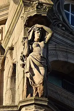 Semi-nude female figure holding roses over her shoulder, floor 5, Tower façade at corner of Princes Street and South St David Street