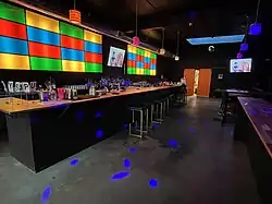 Photograph of the interior of a bar with illuminated cubes in the background