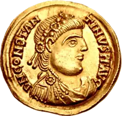 A gold coin showing the profile of a man wearing a wreath