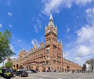 red stone building with tall clock tower in corner