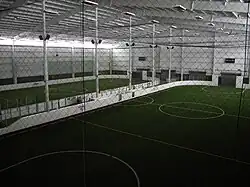 This picture is showing an indoor soccer arena with rebound boards surrounding it