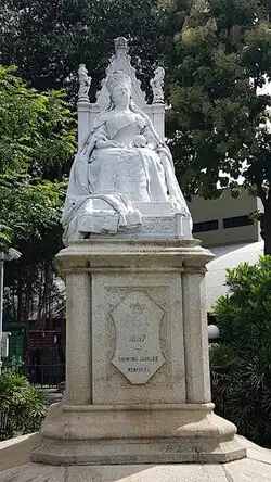 A marble statue of Queen Victoria atop a granite pedestal.