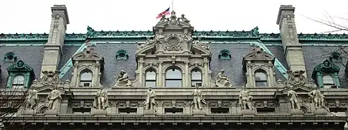 Photograph showing the elaborate details of the mansard roof, with carved statues in front