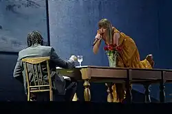 Swift singing onto a mic while crawling on a table