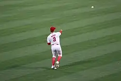 Ward, with his back turned to the camera, throwing a ball toward the infield with his right arm.