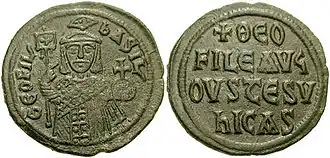 Image of bronze coin, a standing crowned man holding a labarum and a globus cruciger on the obverse, with a Greek-Latin inscription on the reverse