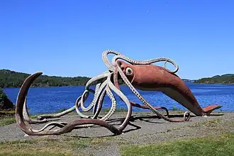 #45 (2/11/1878), A "life-sized" (55-foot) concrete and metal sculpture of the Thimble Tickle giant squid of 1878. Completed in 2001 and weighing 4 tonnes, it was designed by Don Foulds and built by him and his students, following a CA$100,000 government contribution (equivalent to US$64,568 in 2024).