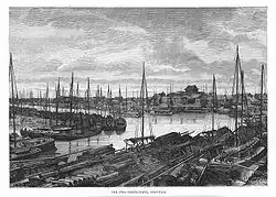 Nineteenth century engraving of river port with large number of single-masted flat bottom boats berthed