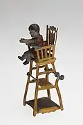 Baby in highchair, tin toy with moveable parts, German manufacture, before 1914