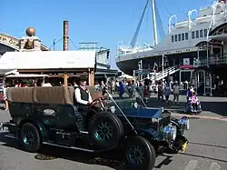 A black turn-of-the-20th-century-style car with no roof
