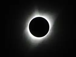 An image of a total solar eclipse at Orin Junction, Wyoming in 2017. A total solar eclipse happens when the Moon completely blocks the face of the Sun. It is the result of a cosmic coincidence. Even though the Sun is about 400 times bigger than the Moon, it is also about 400 times farther away. This makes the Sun and the Moon appear almost exactly the same size in our sky.