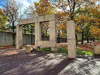 A sculpture of large granite blocks with pavers and trees