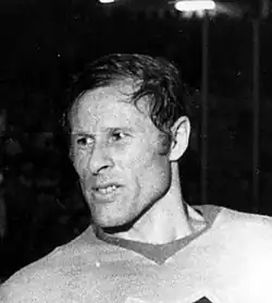 Black and white photo of an adult male wearing a hockey jersey