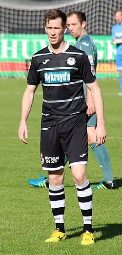 footballer standing in uniform on field