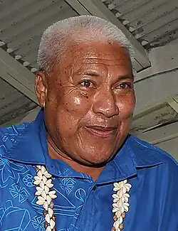 Man with brown skin, short Grey hair, and blue shirt.