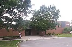 One-storey red brick building, with offices to the left of a main entrance, and an auditorium to the right