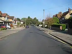 Wide, leafy suburban road with 1930s detached houses