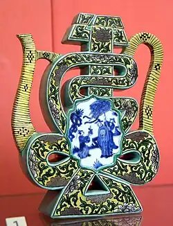 Wine pot in the shape of Shou character. Qing dynasty, Kangxi reign period, 1680–1720 CE. Porcelain painted in underglaze cobalt blue and overglaze colored enamels. From Jingdezhen, China